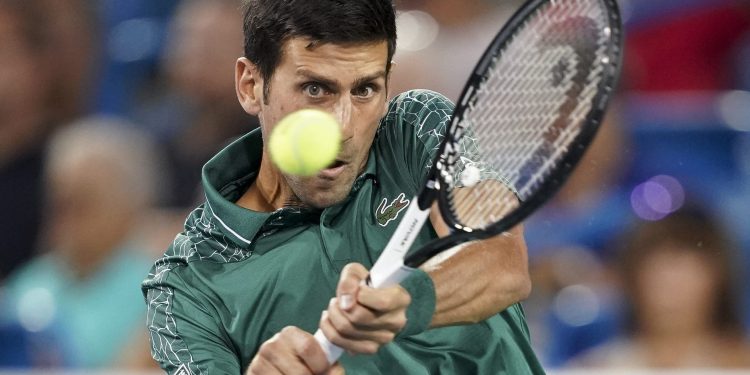 Novak Djokovic returns to Steve Johnson in the first round of the Cincinnati Open tennis tournament