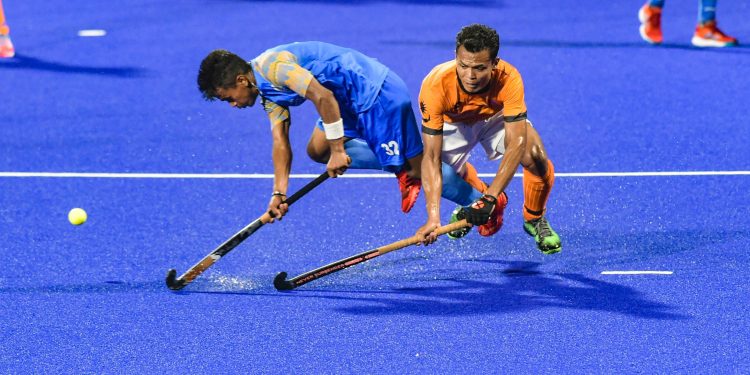 India's Vivek Prasad (L) tries to hit the ball during their men's hockey semifinal match against Malaysia at the Asian Games