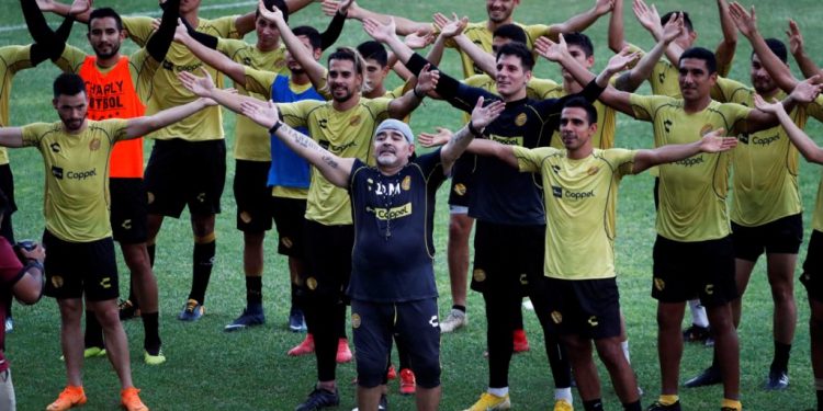 Diego Maradona sings with the Dorados players and fans (not in picture) on his first practice session with the team