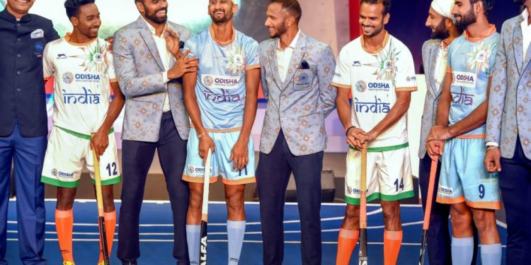 Indian men's hockey team players and coach Harendra Singh (L) during the launch of new home and away kit for the World Cup