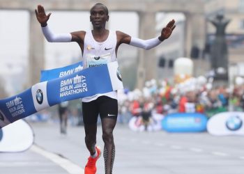 Kenyan Eliud Kipchoge raises his arms in delight after reaching the finish line to create a new world record at the Berlin Marathon, Sunday 