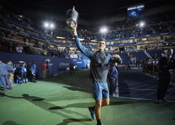 Novak Djokovic celebrates with the US Open winner's trophy
