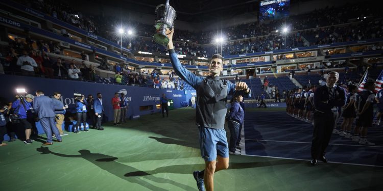 Novak Djokovic celebrates with the US Open winner's trophy