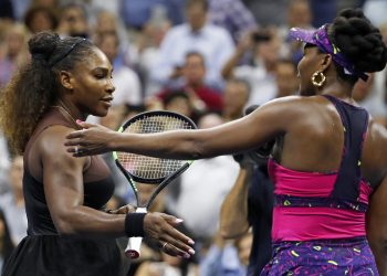Serena Williams (L) meets her sister Venus after their match during the third round of the US Open tennis tournament, Friday