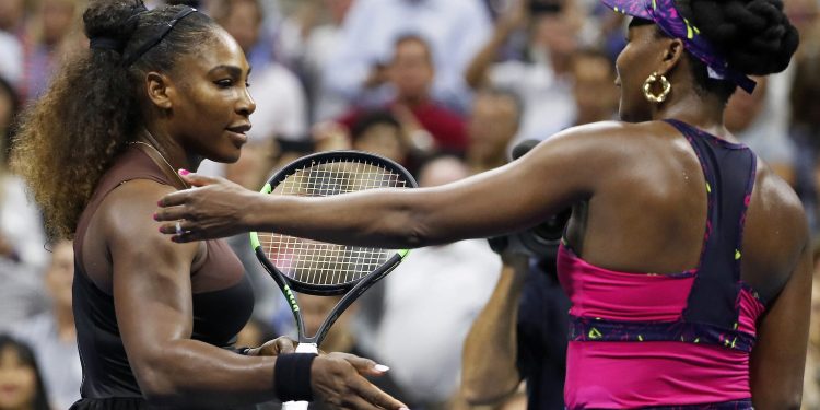 Serena Williams (L) meets her sister Venus after their match during the third round of the US Open tennis tournament, Friday