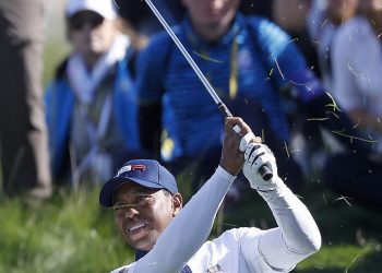 Tiger Woods plays from the rough on the fifth during a foursome match in Paris, Saturday  