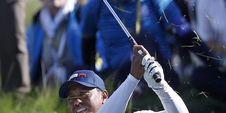 Tiger Woods plays from the rough on the fifth during a foursome match in Paris, Saturday  