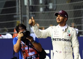 Lewis Hamilton acknowledges the crowd after winning the Singapore Grand Prix at the Marina Bay Street Circuit