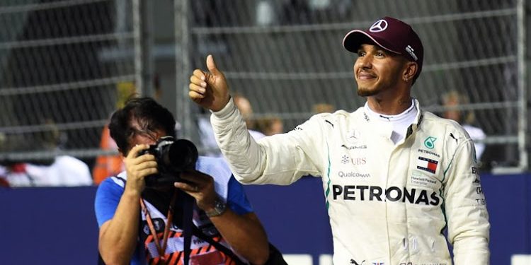 Lewis Hamilton acknowledges the crowd after winning the Singapore Grand Prix at the Marina Bay Street Circuit