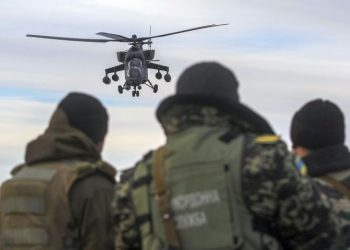A Russian army MI-35 military helicopter patrols the area as Ukrainian servicemen guard a checkpoint near the village of Strelkovo in Kherson region adjacent to Crimea, March 16, 2014. Ukraine accused "Kremlin agents" on Saturday of fomenting deadly violence in Russian-speaking cities and urged people not to rise to provocations its new leaders fear Moscow may use to justify a further invasion after its takeover of Crimea.   REUTERS/Valentyn Ogirenko  (UKRAINE - Tags: POLITICS CIVIL UNREST MILITARY) - RTR3HBEG