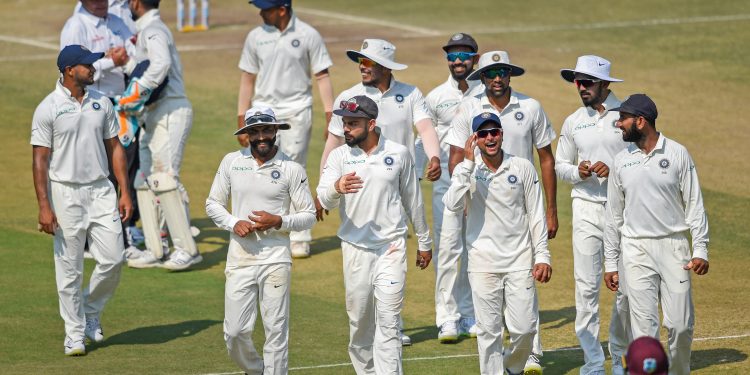 Indian players celebrate their victory over West Indies in their first Test match, in Rajkot