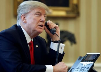 U.S. President Donald Trump speaks by phone in the Oval Office at the White