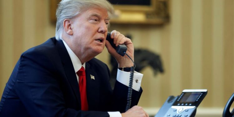 U.S. President Donald Trump speaks by phone in the Oval Office at the White