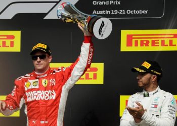 Kimi Raikkonen (L) holds the winner’s trophy aloft in celebration as Lewis Hamilton applauds the Finn at Austin, Sunday