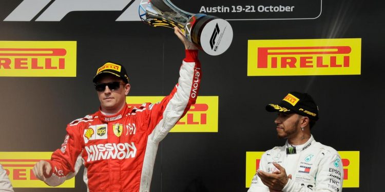 Kimi Raikkonen (L) holds the winner’s trophy aloft in celebration as Lewis Hamilton applauds the Finn at Austin, Sunday