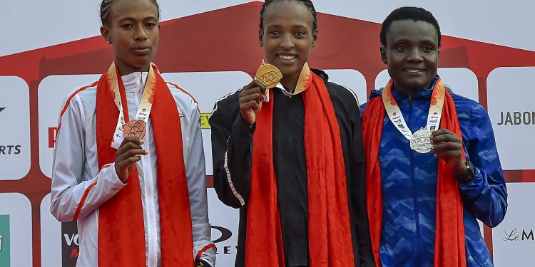 Tsehay Gemechu (C), Joyciline Jepkosgei (R) and Zeineba Yimer pose for photos during the medal ceremony at Jawaharlal Nehru Stadium in New Delhi, Sunday