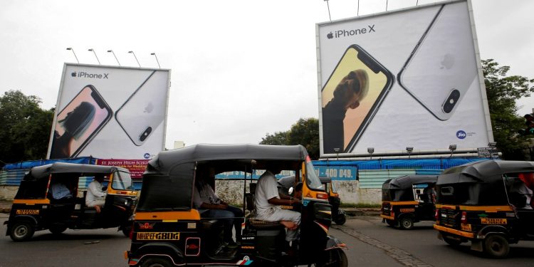 FILE PHOTO: Auto-rickshaws drive past the hoardings of Apple iPhone X mobile phones in Mumbai, India July 27, 2018. REUTERS/Francis Mascarenhas/File Photo