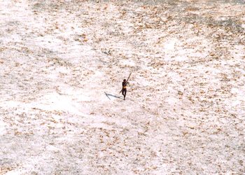FILE PHOTO: A Sentinel tribal man aims with his bow and arrow at an Indian Coast Guard helicopter as it flies over the island for a survey of the damage caused by the tsunami in India's Andaman and Nicobar archipelago, December 28, 2004. REUTERS/Indian Coast Guard/Handout