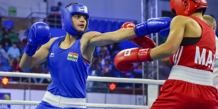 Sonia (in blue) lands punch on his Moroccan opponent Toujani Doaa (in red) during their bout at women’s World Championships in New Delhi, Saturday           