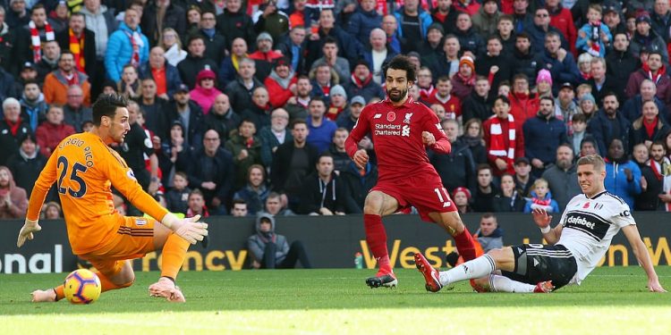 Mo Salah (in red) slots the ball under a hapless Fulham goalie Sergio Rico for Liverpool’s opening goal, Sunday