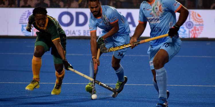 India’s Lalit Upadhyay (C) dribbles pasta South African player as another Indian player looks on during their match at the Kalinga Stadium, Wednesday