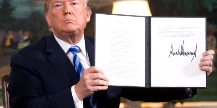File photo of US President Donald Trump signing a document reinstating sanctions against Iran after announcing the US withdrawal from the Iran Nuclear deal, in the Diplomatic Reception Room at the White House in Washington, DC, on May 8, 2018. PHOTO: AFP