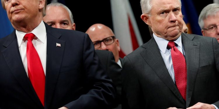 U.S. President Donald Trump and Attorney General Jeff Sessions button their coats as they stand for the national anthem at a graduation ceremony at the FBI Academy on the grounds of Marine Corps Base Quantico in Quantico, Virginia, U.S. December 15, 2017.  REUTERS/Jonathan Ernst/File Photo