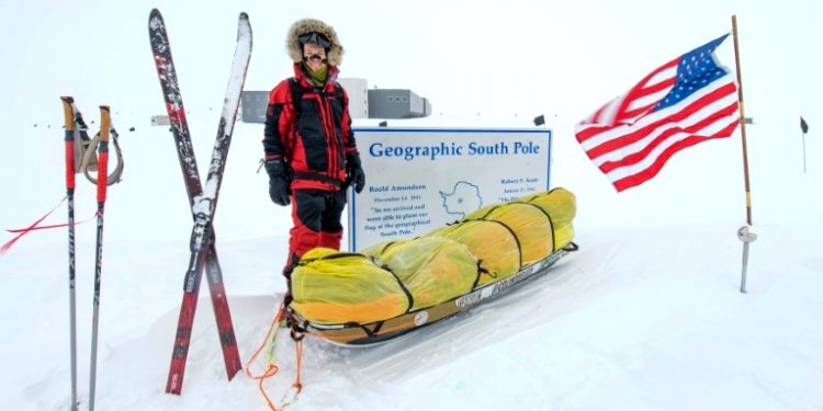 American adventurer Colin O'Brady poses for a photo at the Geographic South Pole sign in Antarctica (AFP)