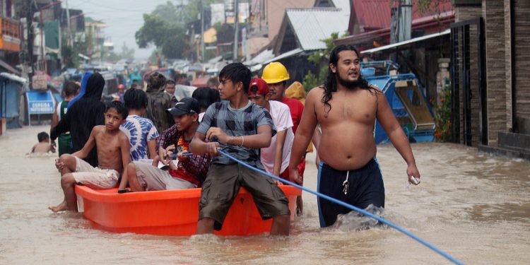 Filipino residents ride on a boat during a rescue operation at a flooded community in the town of Bulan, Sorsogon province, Philippines, Dec. 29, 2018. (AGENCY)