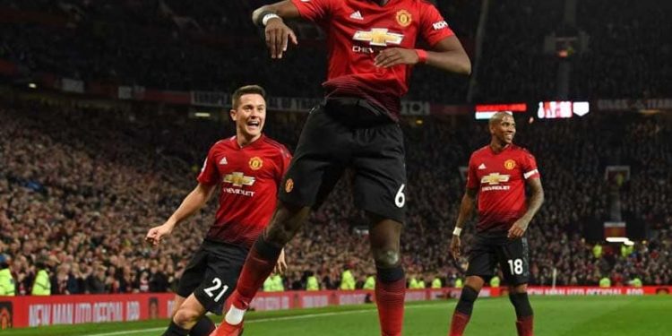 Manchester United’s Paul Pogba (C) leaps high in celebration after scoring one of his two goals against Bournemouth while teammates Ander Herrera (L) and Ashley Young join in at Old Trafford Sunday