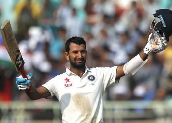India's Cheteshwar Pujara raises his bat and helmet to celebrate scoring a century on the first day of their second cricket test match against England in Visakhapatnam, India, Thursday, Nov. 17, 2016. (AP Photo/Aijaz Rahi)