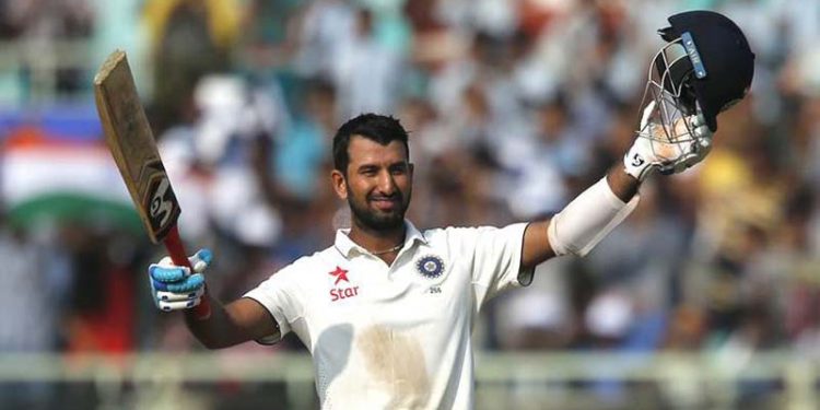 India's Cheteshwar Pujara raises his bat and helmet to celebrate scoring a century on the first day of their second cricket test match against England in Visakhapatnam, India, Thursday, Nov. 17, 2016. (AP Photo/Aijaz Rahi)
