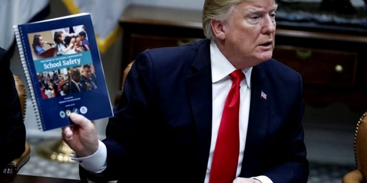 Donald Trump with the School safety manual (AFP)