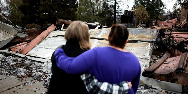 Irma Corona (R) comforts neighbor Gerryann Wulbern in front of the remains of Wulbern's home after the two returned for the first time since the Camp Fire in Paradise, California, U.S. November 22, 2018. (REUTERS)