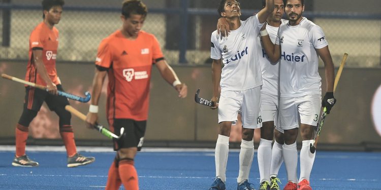 Pakistan players (in white) celebrate after scoring against Malaysia at the Kalinga Stadium, Wednesday