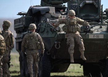 US Army serviceman jumps from armoured vehicle during the NATO Wind Spring 15 military exercise at Smardan military shooting range on April 21, 2015. (AFP)