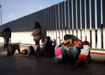 A migrant sits with his children as they wait to hear if their number is called to apply for asylum in the United States, at the border, Friday, Jan. 25, 2019, in Tijuana, Mexico. The Trump administration on Friday will start forcing some asylum seekers to wait in Mexico while their cases wind through U.S. courts, an official said, launching what could become one of the more significant changes to the immigration system in years. (AP)