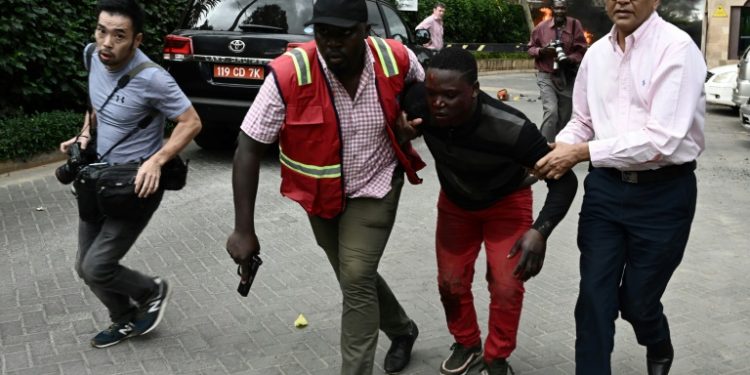 Nairobi attack: An injured man is evacuated from the Dusit2 hotel and office complex (AFP)
