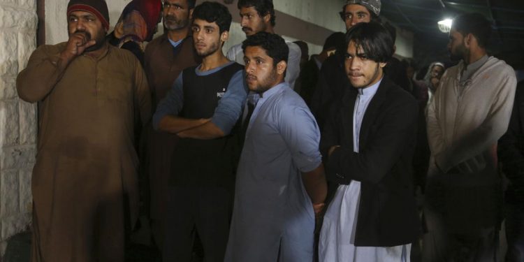 People wait outside the mortuary to receive bodies of their family members killed in an accident, in Karachi, Pakistan, Tusday, Jan.22,2019. A Pakistani official syas a bus collided with an oil tanker, killing many passengers and leaving others with severe burns. (AP/Fareed Khan)
