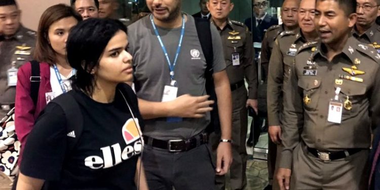 In this Jan. 7, 2019, file photo released by the Immigration Bureau, Saudi woman Rahaf Mohammed Alqunun, foreground, walks by Chief of Immigration Police Maj. Gen. Surachate Hakparn, right, before leaving the Suvarnabhumi Airport in Bangkok, Thailand. Australia says it is considering granting the Saudi who fled from her family refugee resettlement based on referral by the U.N. (AP)