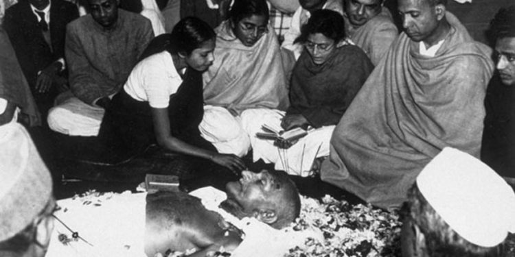 The niece of Mahatma Gandhi places flower petals on his brow as he lies in state at Birla House, New Delhi, after his assassination. Immediately after this picture was taken the procession left for the burning ghat on the banks of the river Jumna, where the cremation took place. (AFP/Getty Images)