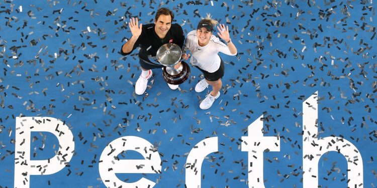 In an ariel view Roger Federer (L) and Belinda Bencic pose for the shutterbugs with the winner’s trophy at Perth Saturday