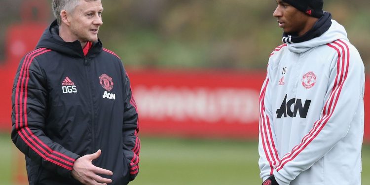 Manchester United interim manager Ole Gunnar Solskjaer (L) speaks with Marcus Rashford during their training session 