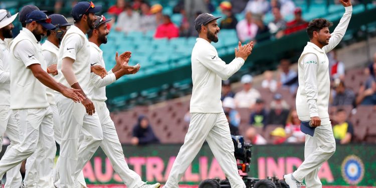 Kuldeep Yadav (R) reacts as he walks off the ground with captain Virat Kohli (2nd R) and teammates after taking five wickets during the fourth day's play of the fourth Test against Australia at the Sydney Cricket Ground
