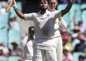 Rishabh Pant (L) celebrates his century  as Australia's Marnus Labuschagne watches at Sydney, Friday