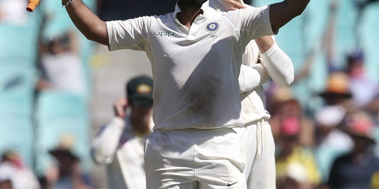 Rishabh Pant (L) celebrates his century as Australia's Marnus Labuschagne watches at Sydney, Friday