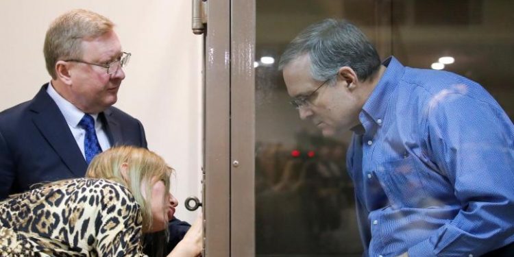 Former US marine Paul Whelan, who was detained by Russia's FSB security service on suspicion of spying, speaks with lawyers while standing in a defendants' cage before a court hearing in Moscow