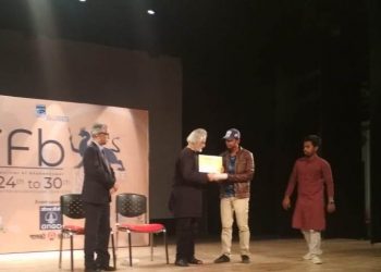 Anand Patwardhan giving award to student filmmaker