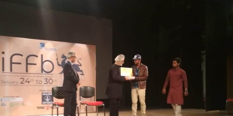 Anand Patwardhan giving award to student filmmaker