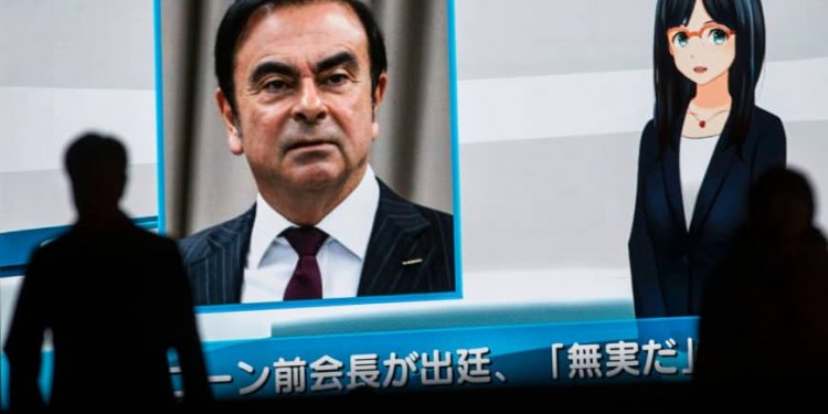 Pedestrians pass by a television screen showing a news program featuring former Nissan Chairman Carlos Ghosn in Tokyo on Tuesday. (AFP)